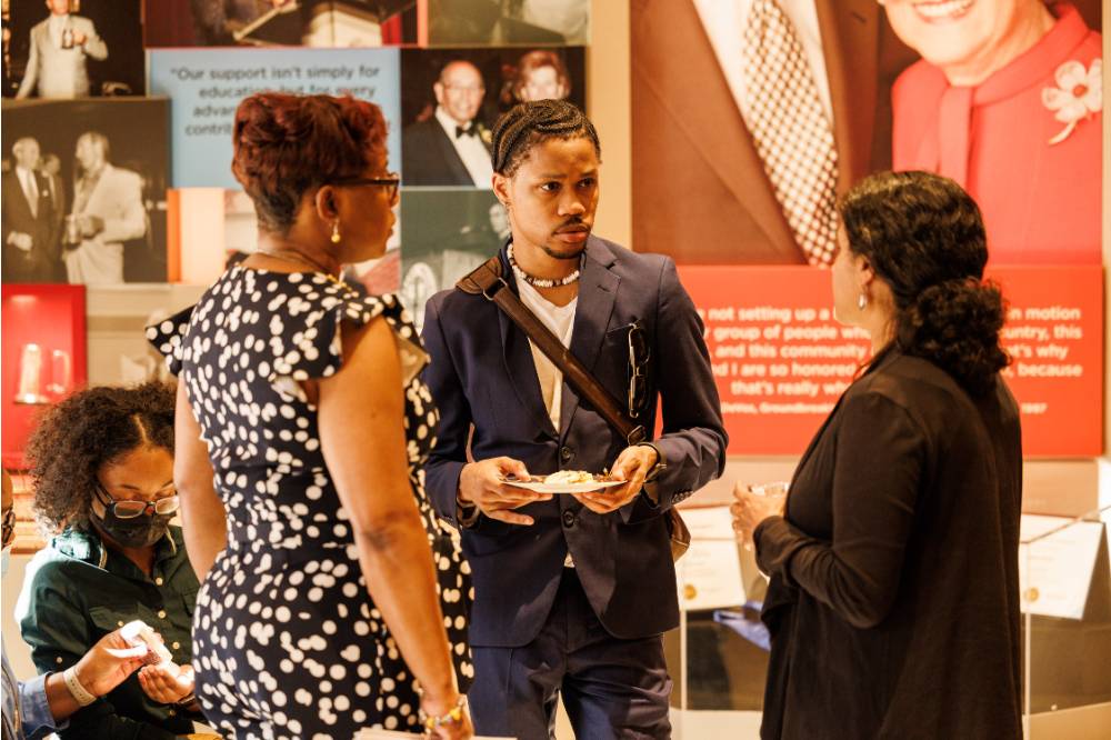 Malik Robinson (middle) in a conversation with attendees